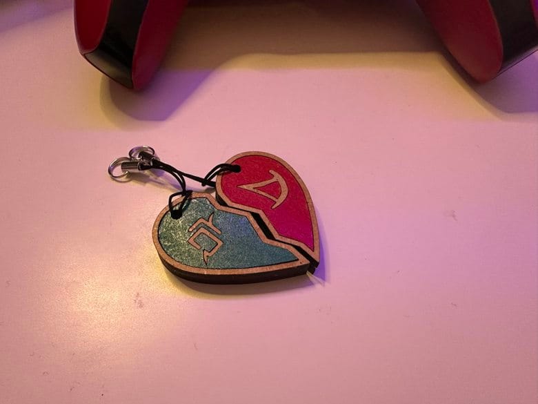 Two keychains forming a heart shape, they have final fantasy 14 symbols as part of the design