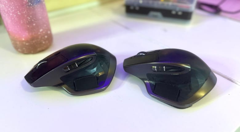 A pair of Logitech MX Masters, with a barely visible plastic part jutting out over the thumbrest