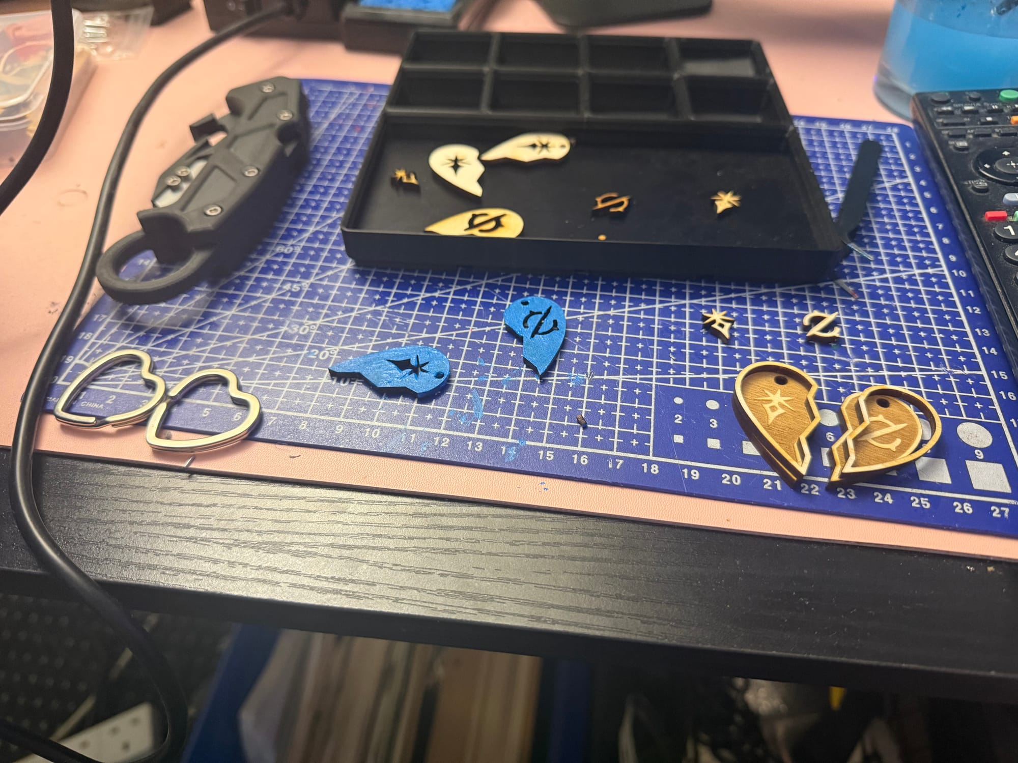 Various pieces of a Final Fantasy 14 keychain scattered on a blue mat